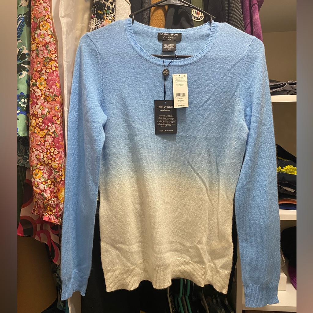 Folded cashmere sweater photographed by a marketplace seller against a plain backdrop